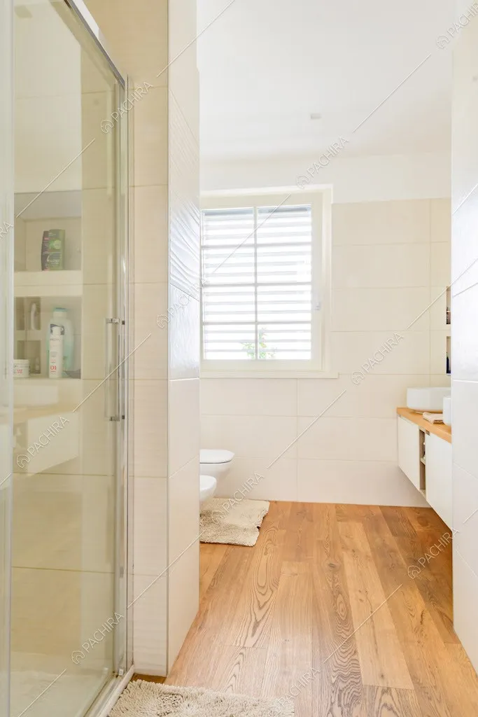 Luminoso bagno con pavimento in parquet e box doccia