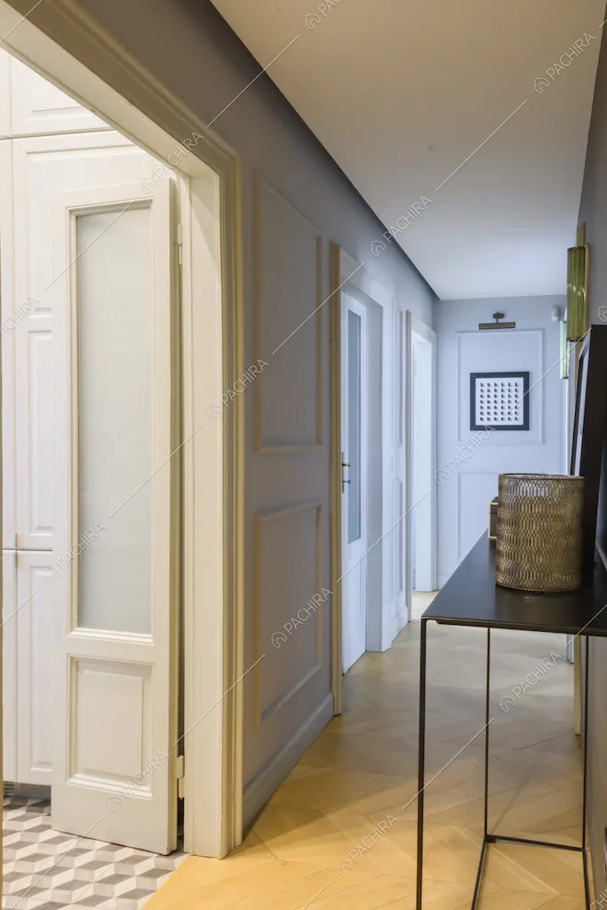 Corridoio con porte d'epoca e pareti bianche