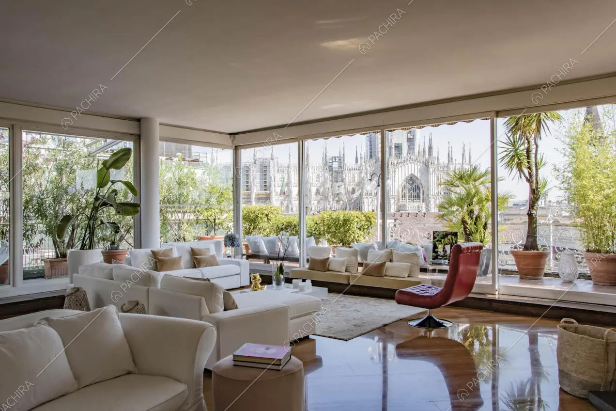 Poltrona rossa di design, divano bianco e pavimento in parquet nella zona living