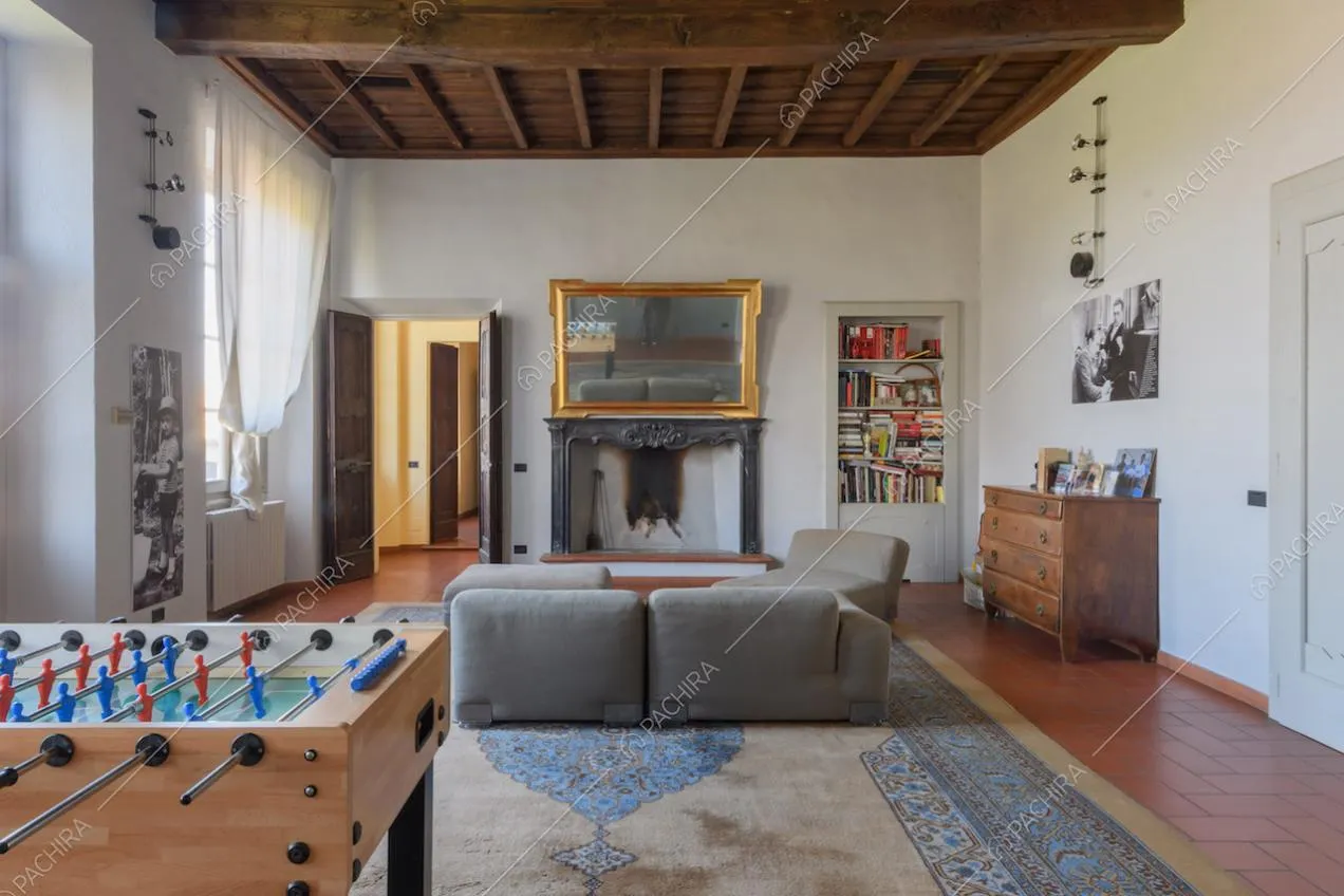 Luminoso salotto con pareti bianche, camino e soffitto a cassettoni