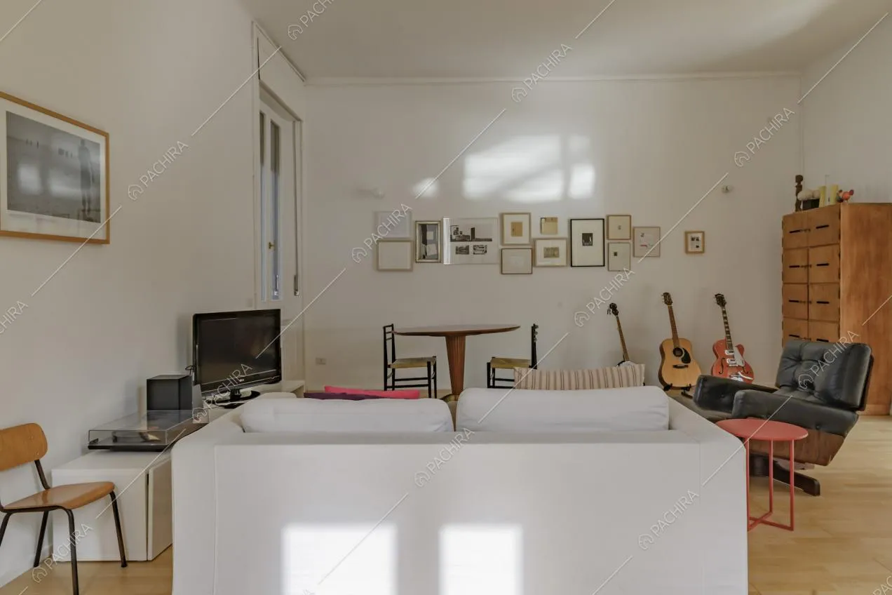 Zona living con divano bianco e poltrona di design 