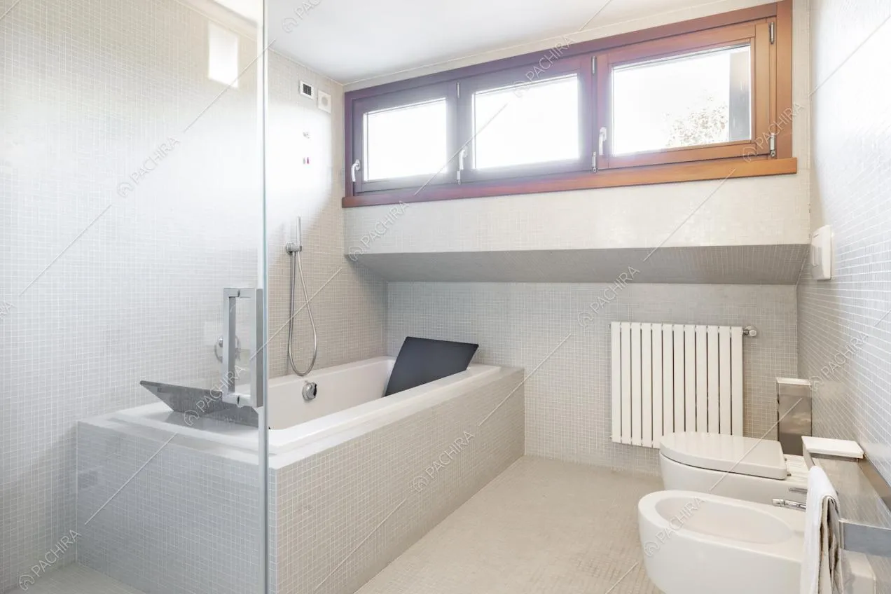 Bagno con vasca e pareti rivestite con piastrelle a mosaico