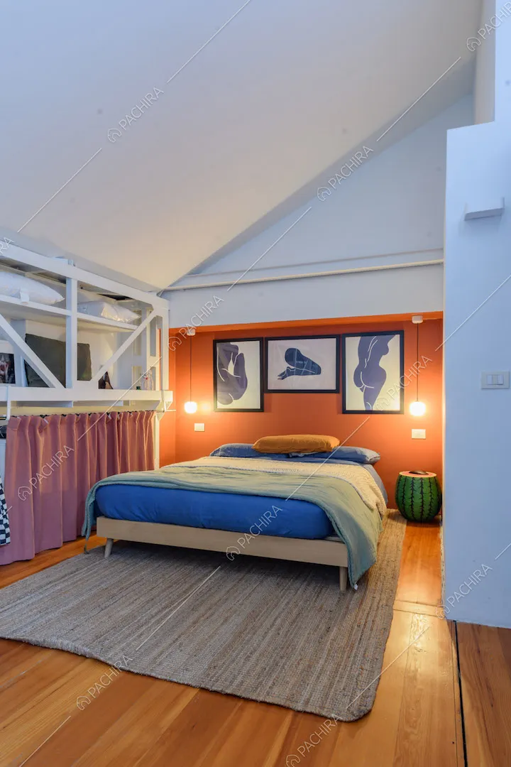 Camera da letto matrimoniale con parete rossa e pavimento in parquet