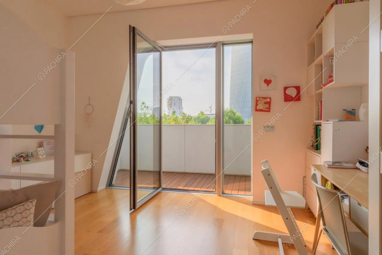 Luminosa camera da letto con scrivania, pavimento in parquet e porta-finestra
