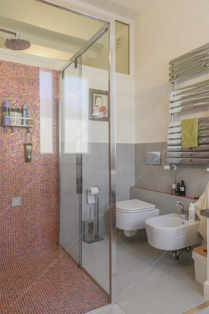 Bagno con ampia cabina doccia in piastrelle