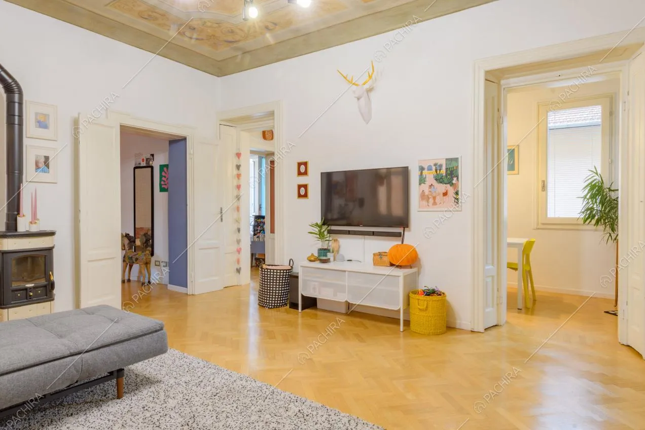 Pavimento in parquet a spina di pesce e divano angolare grigio nella sala
