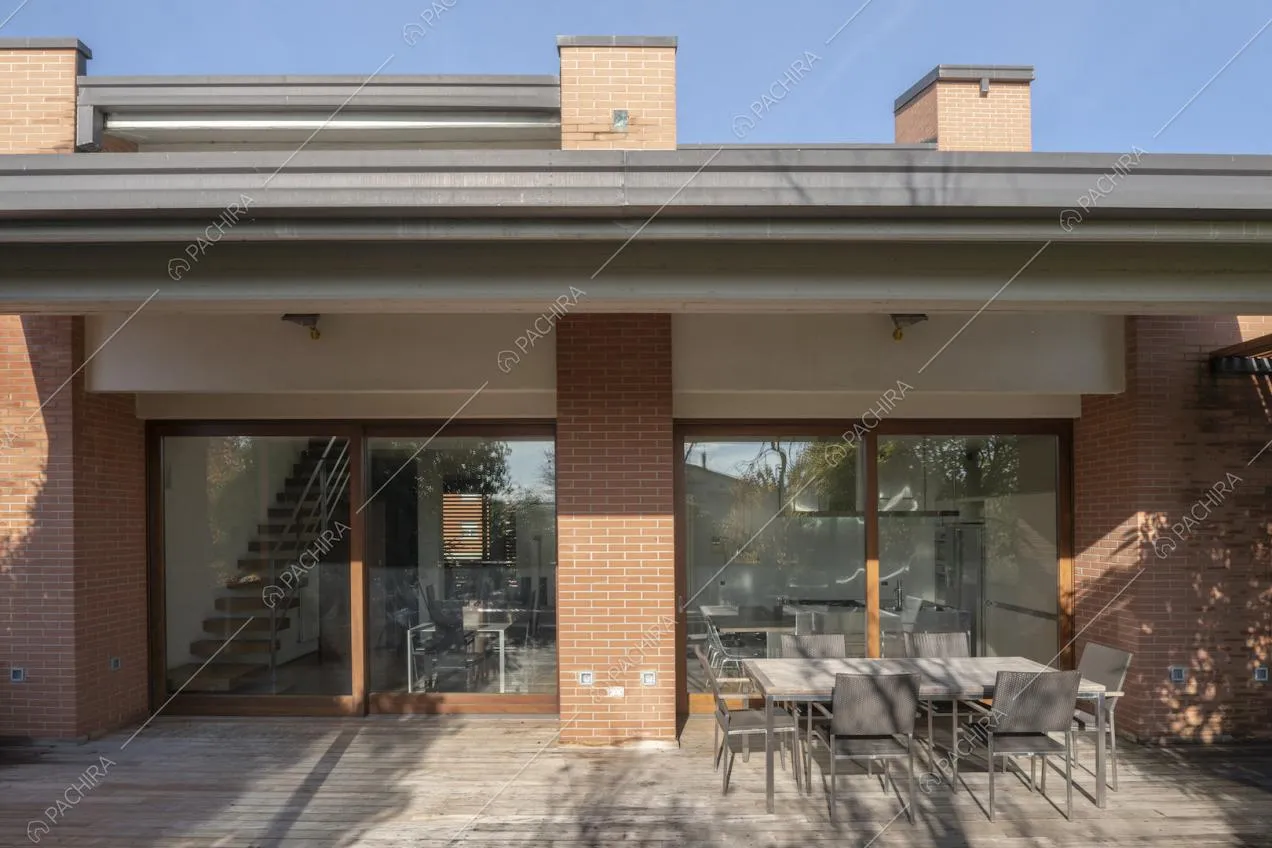 Patio ombreggiato con tavolo da pranzo e sedie da esterni