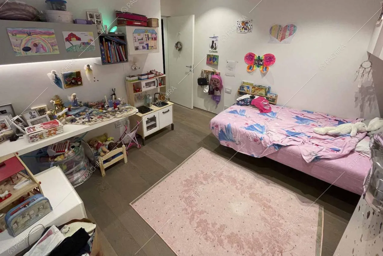 Camera da letto da bambina dalle pareti bianche e pavimento in parquet