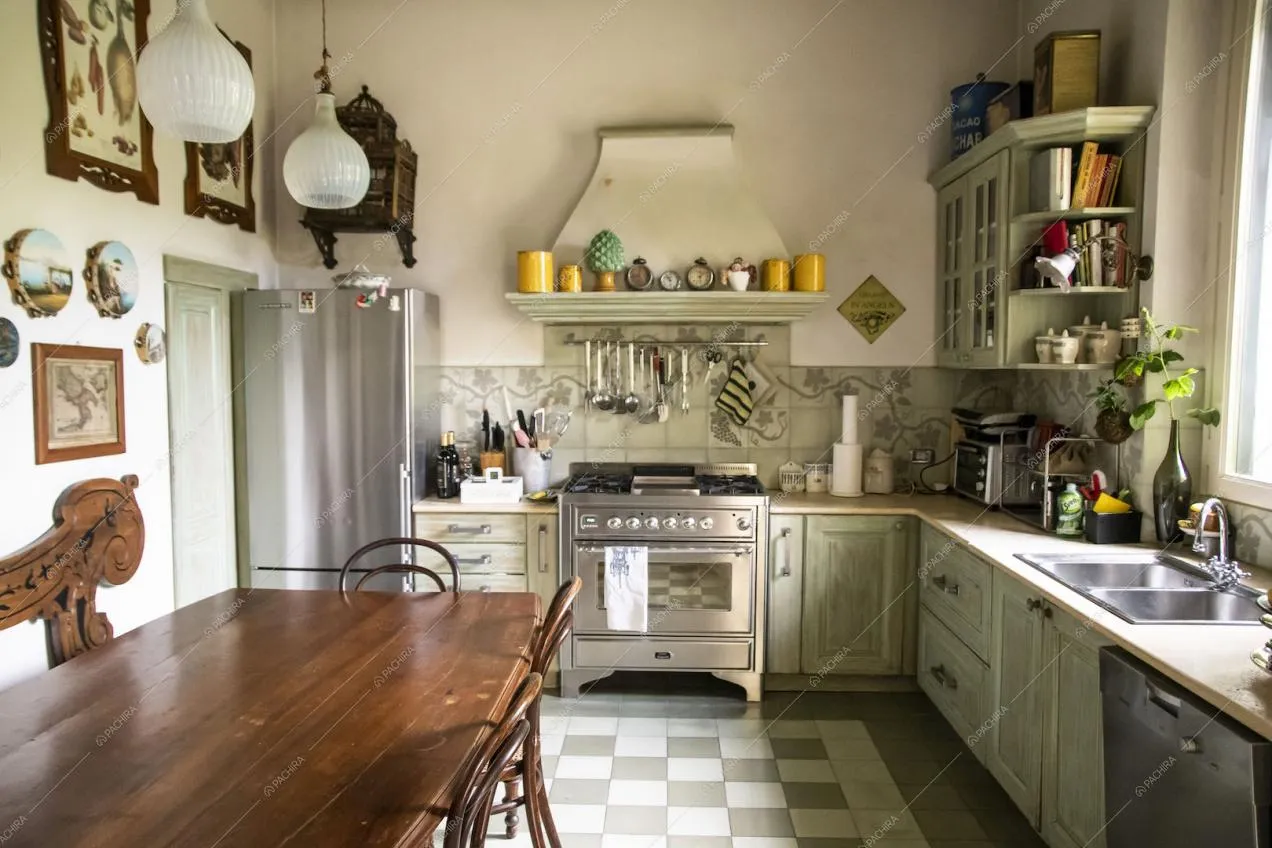 Cucina con pavimento in piastrelle a scacchi, fornelli a gas e tavolo da pranzo in legno