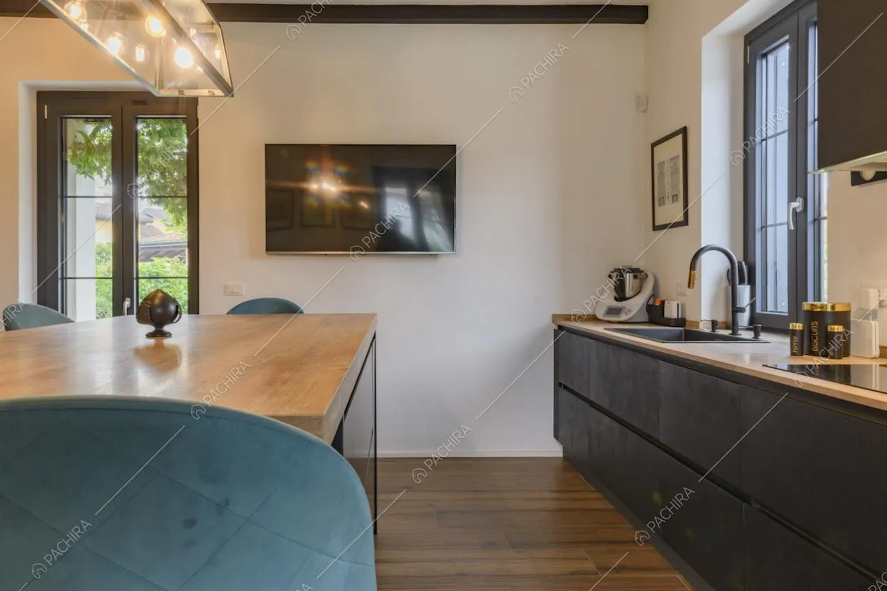 Cucina a parete con mobili scuri e parquet