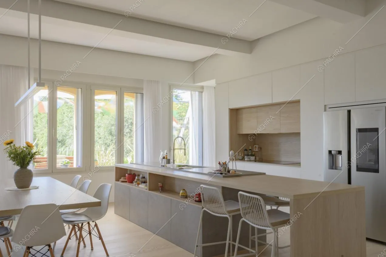 Open space con cucina a isola e sgabelli alti