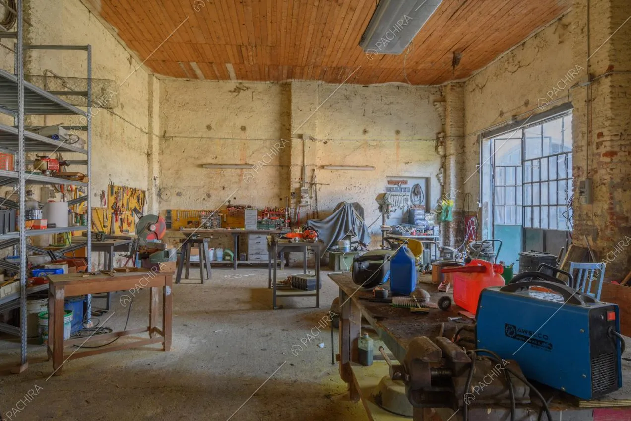Garage con strumenti da lavoro, pareti délabré e porta a vetri in stile industriale