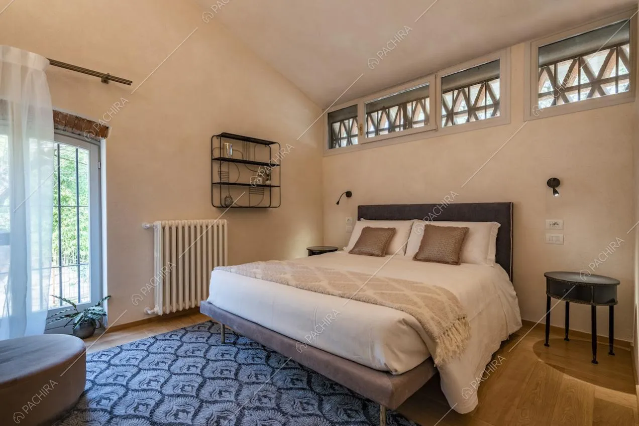 Letto matrimoniale, comodino tondo e tappeto