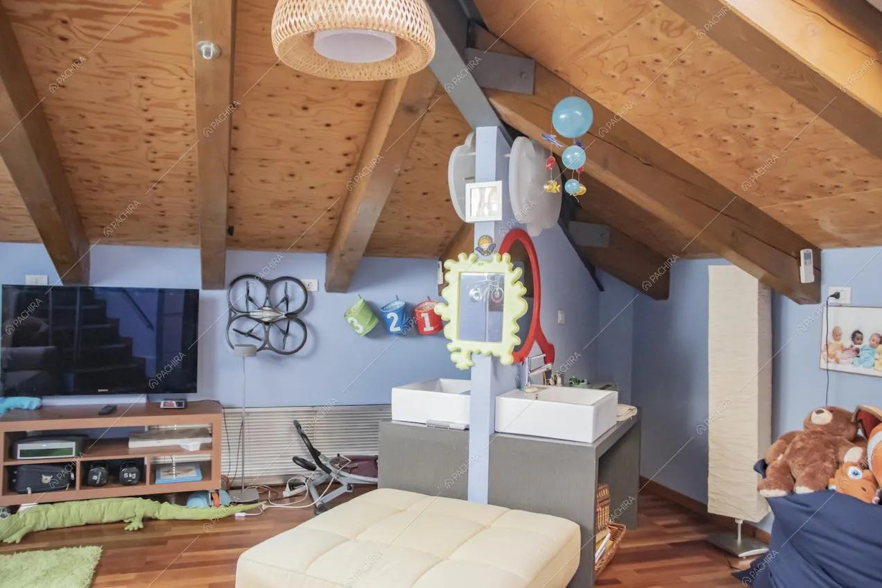 Camera da letto con pavimento in parquet, soffitto con travi in legno a vista e pareti azzurre