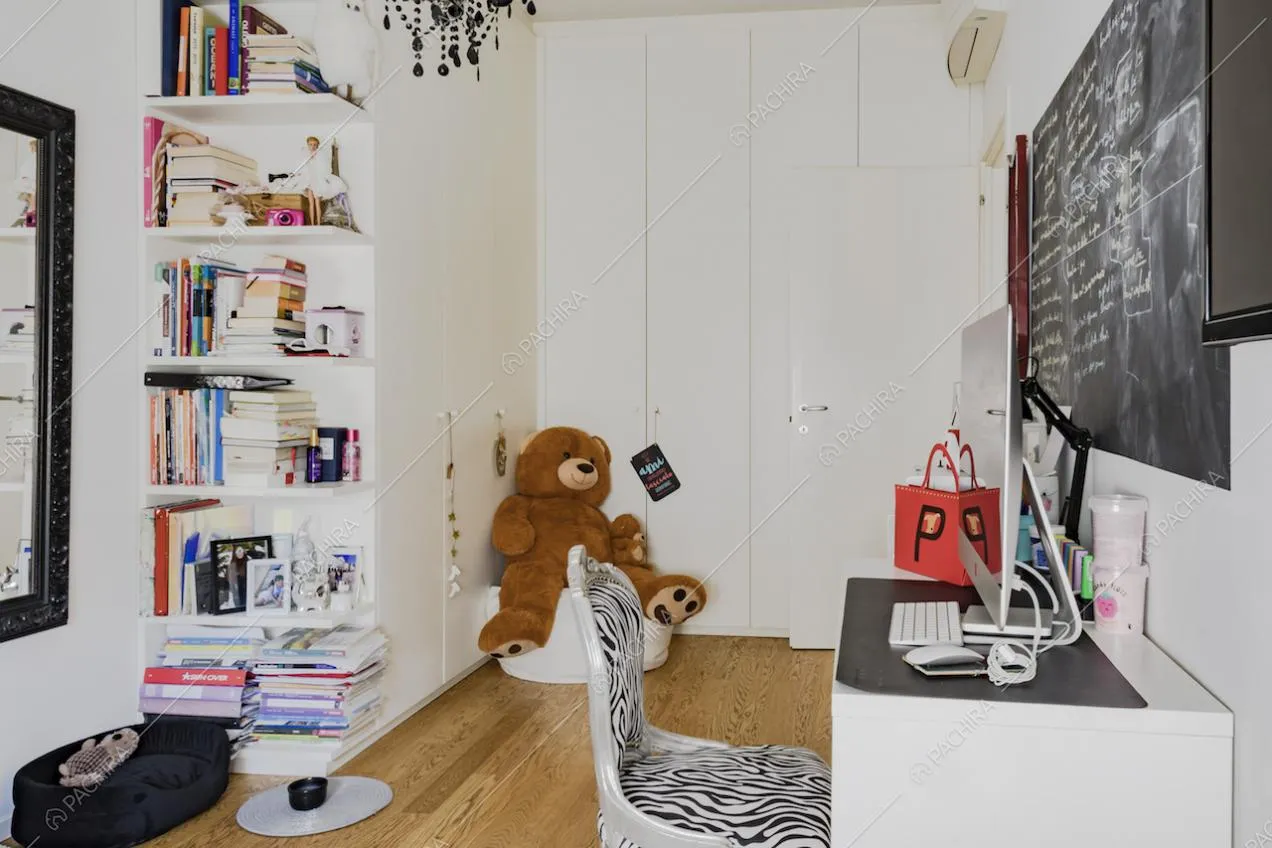 Mensole con libri e grande orso di peluche