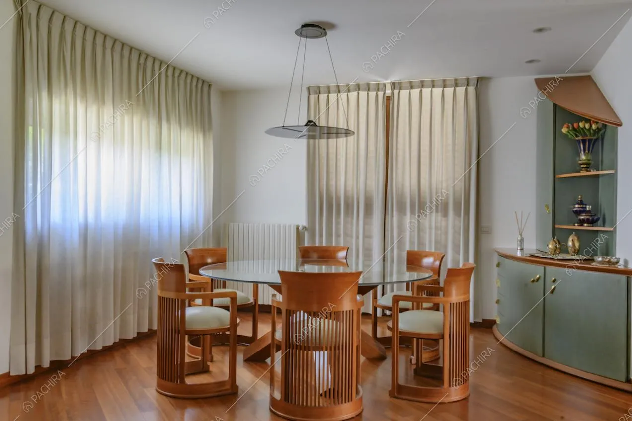 Sala da pranzo con tavolo e sedie di design e ampie vetrate