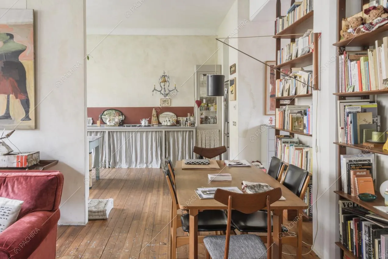Tavolo in legno con sedie di fianco alla libreria