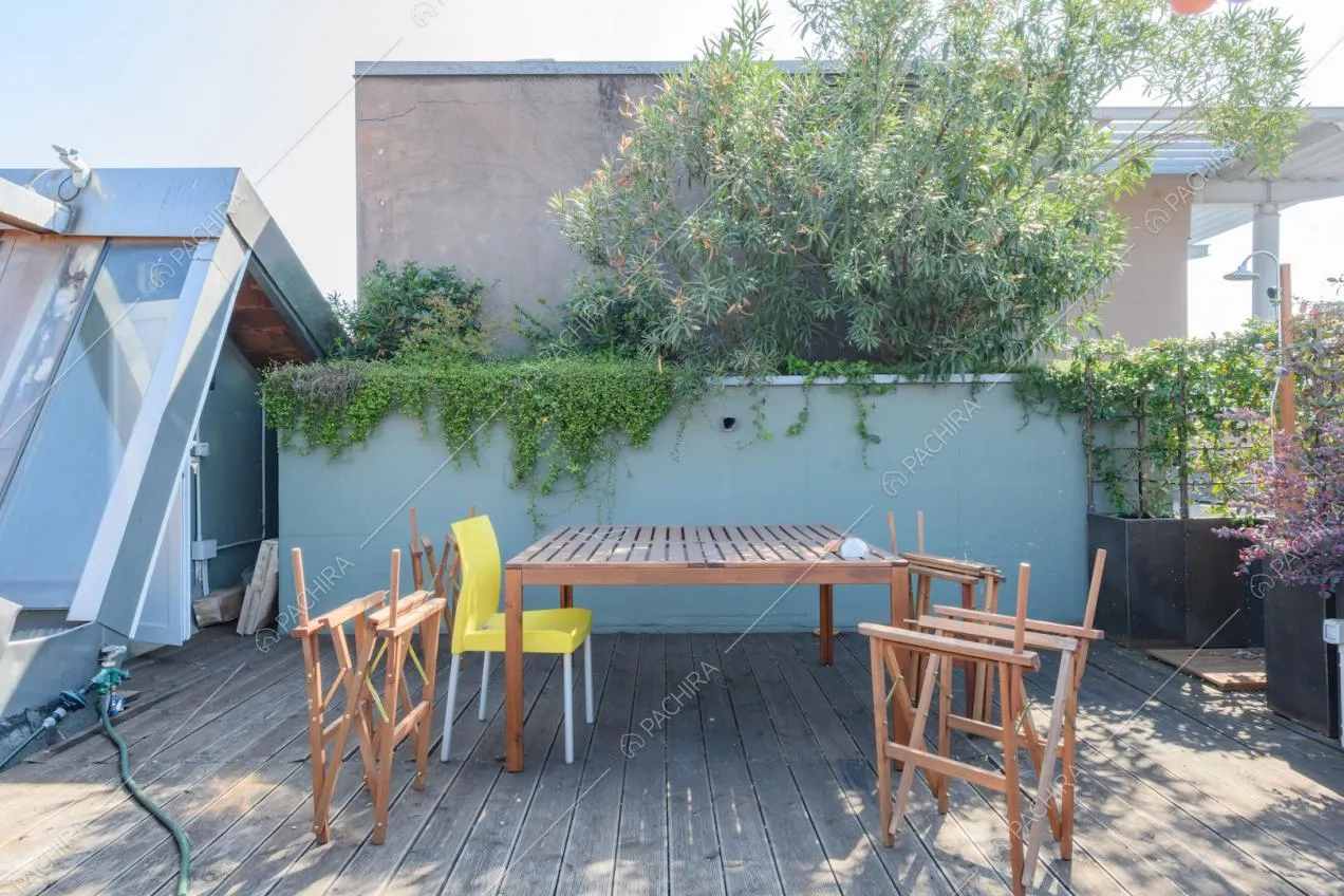 Tavolo da pranzo sulla terrazza con olivo e pavimento in parquet da esterni
