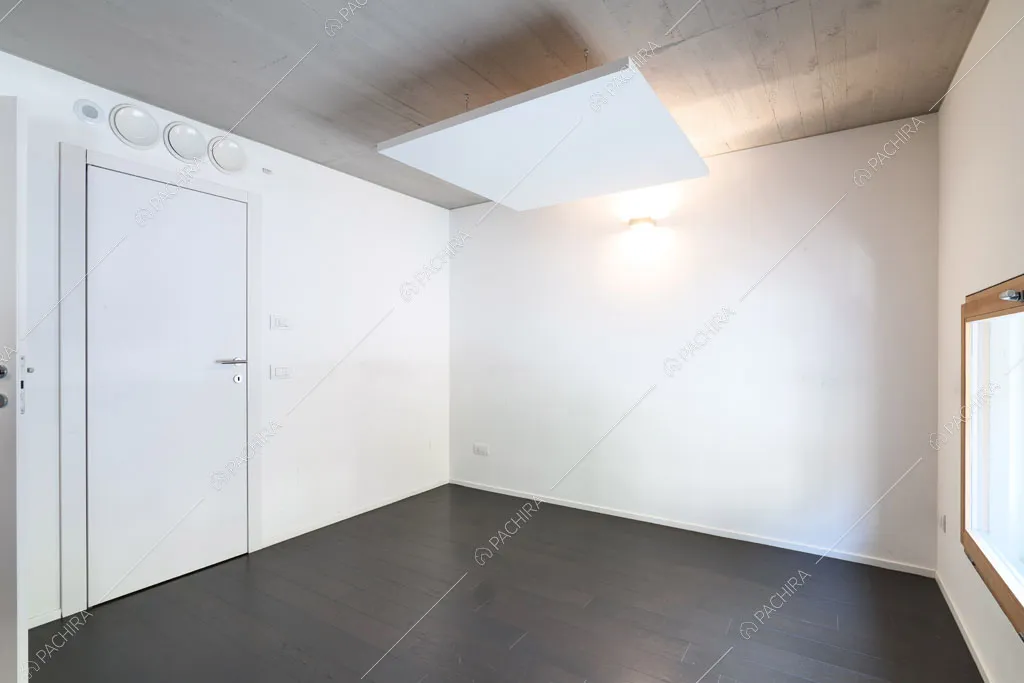 Pareti bianche nella camera dell'espositivo Apocino, location in stile contemporaneo a Milano