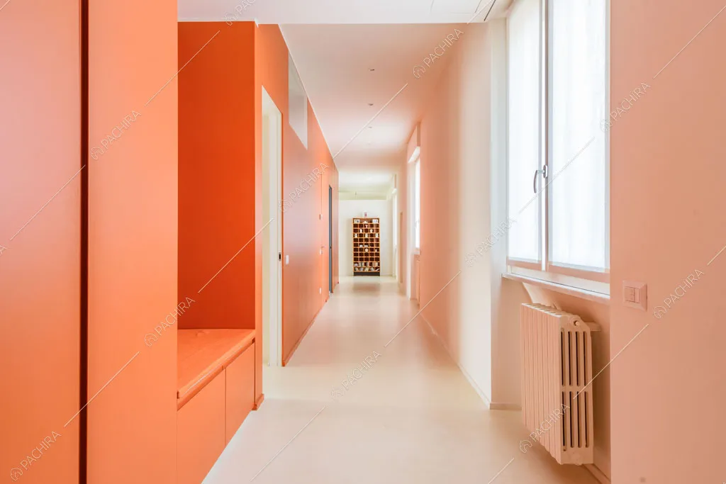 Corridoio dalle nuances arancioni dell'appartamento Papagayo, location in stile contemporaneo a Milano