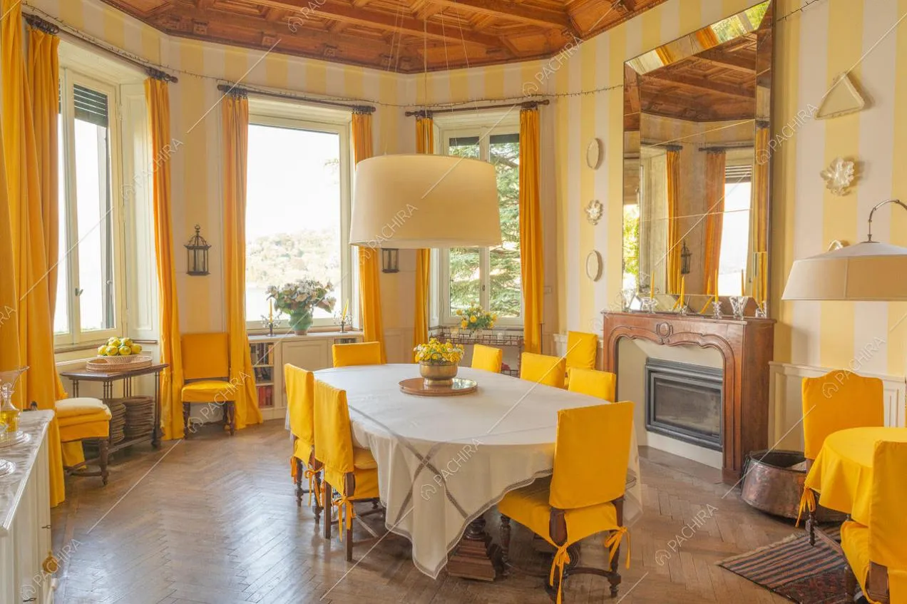 Sala da pranzo con tende e copri sedie color crema