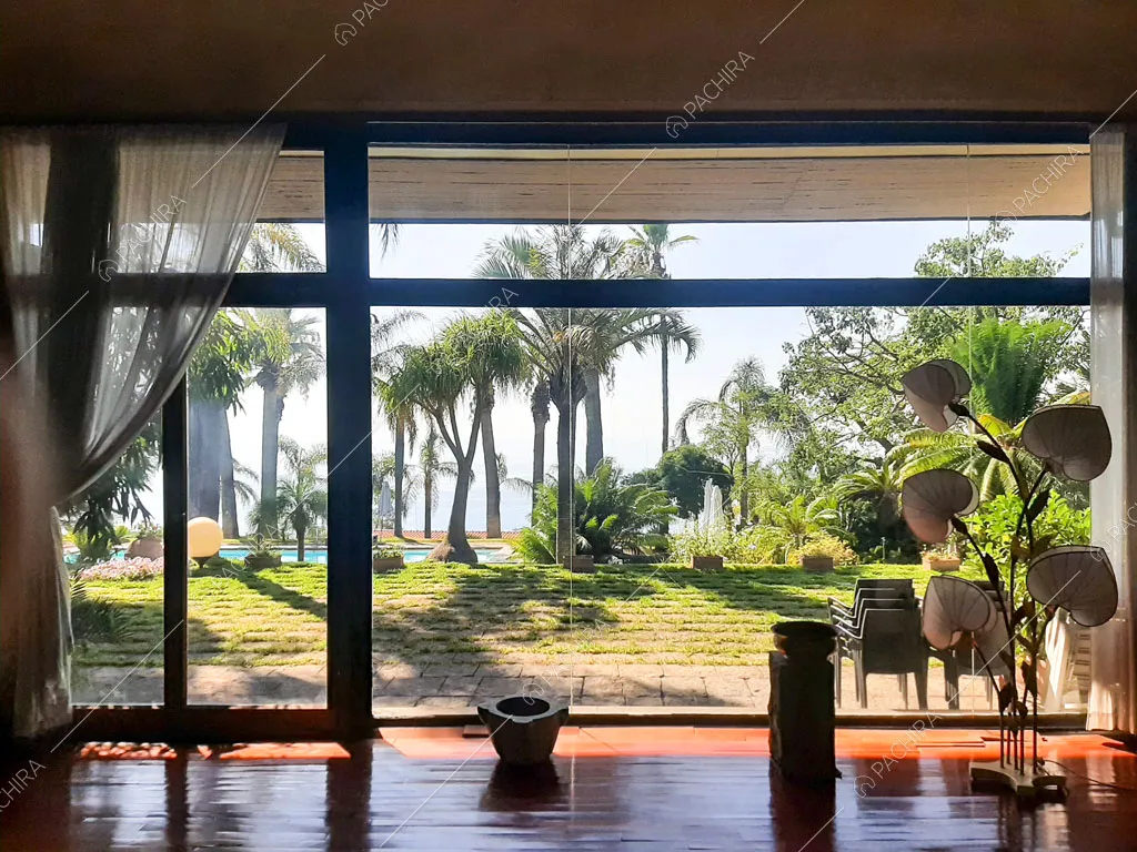 Dalla zona living vista sul giardino e sul mare tramite la parete vetrata