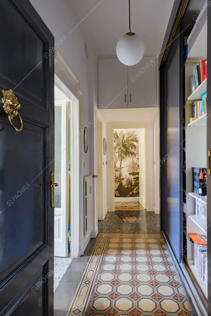 Dalla porta d'ingresso corridoio con pavimento in graniglia e libreria