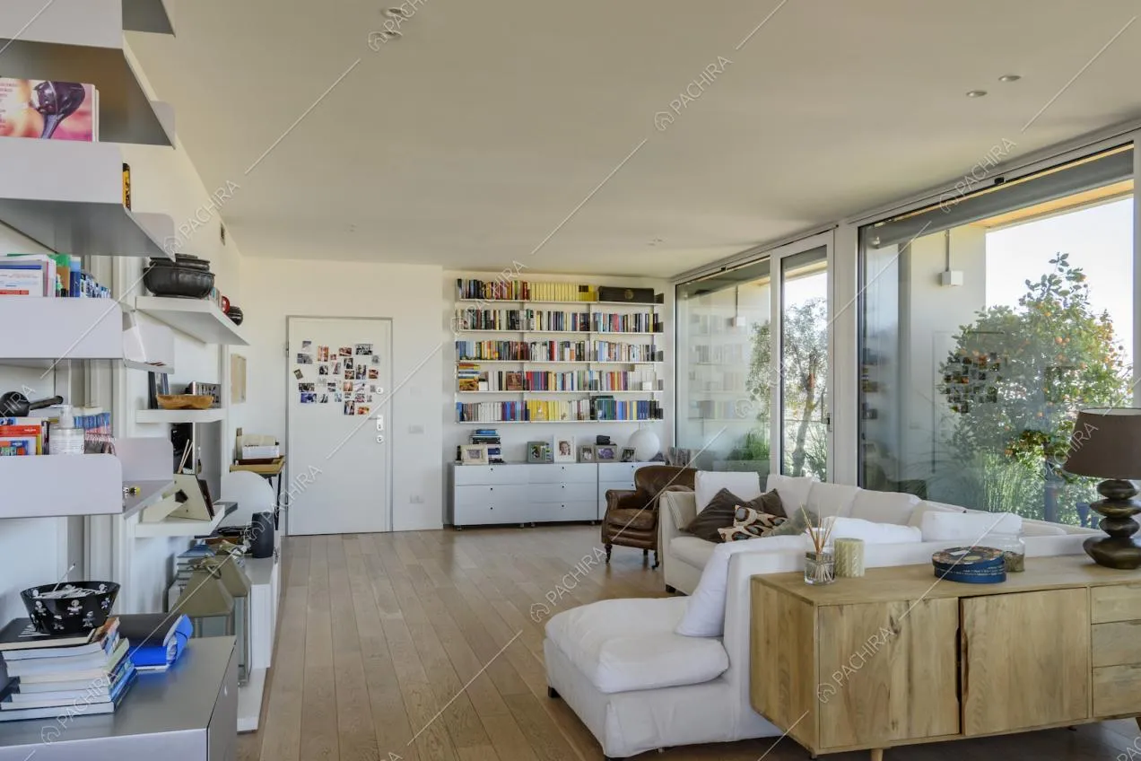 Salotto luminoso con divano bianco e libreria