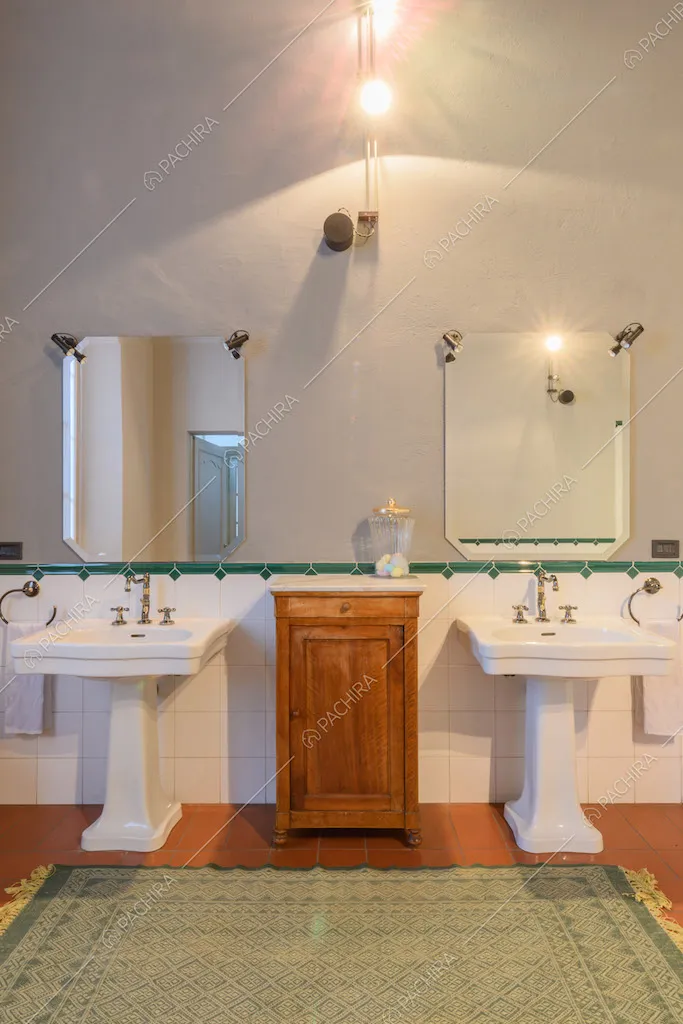 Ampio bagno con doppio lavandino, parete grigia e con piastrelle bianche