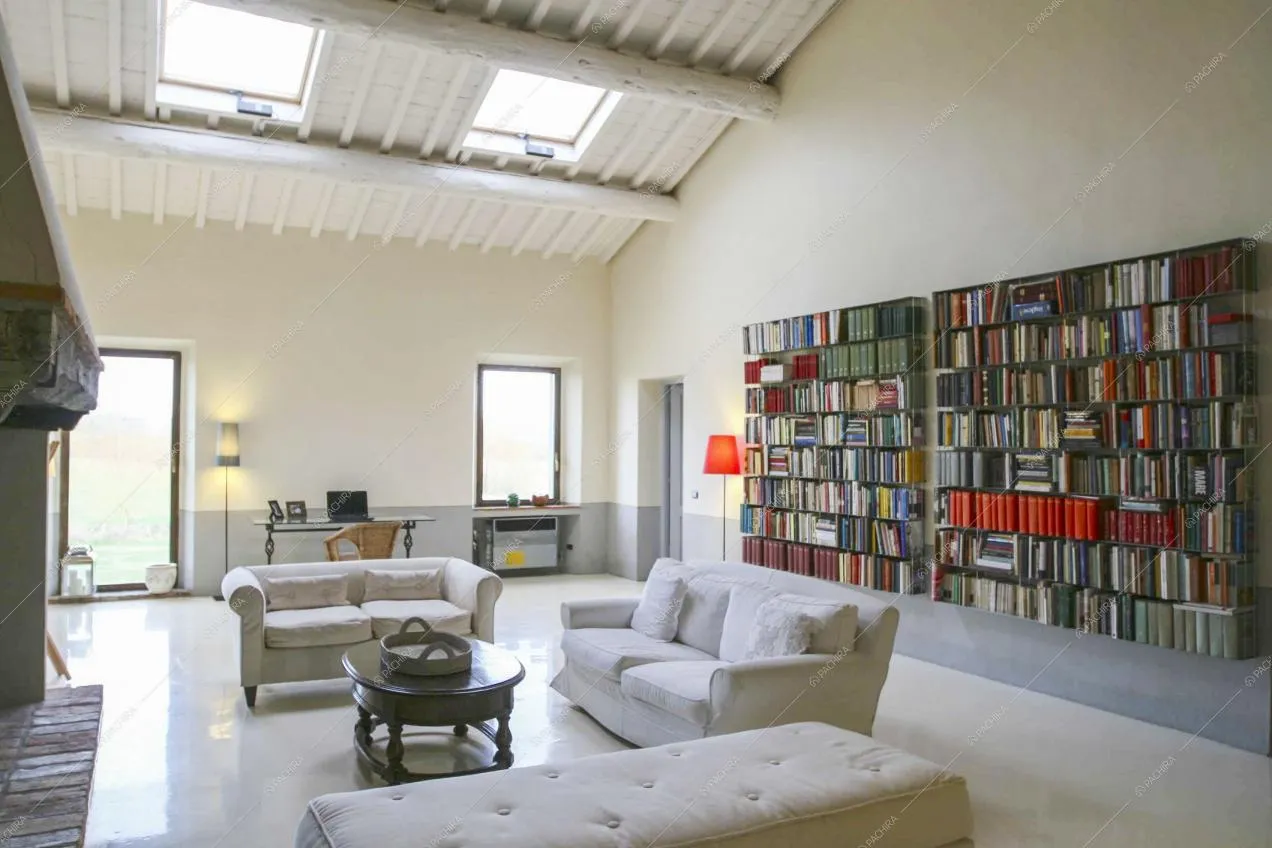 Divani bianchi e libreria a parete