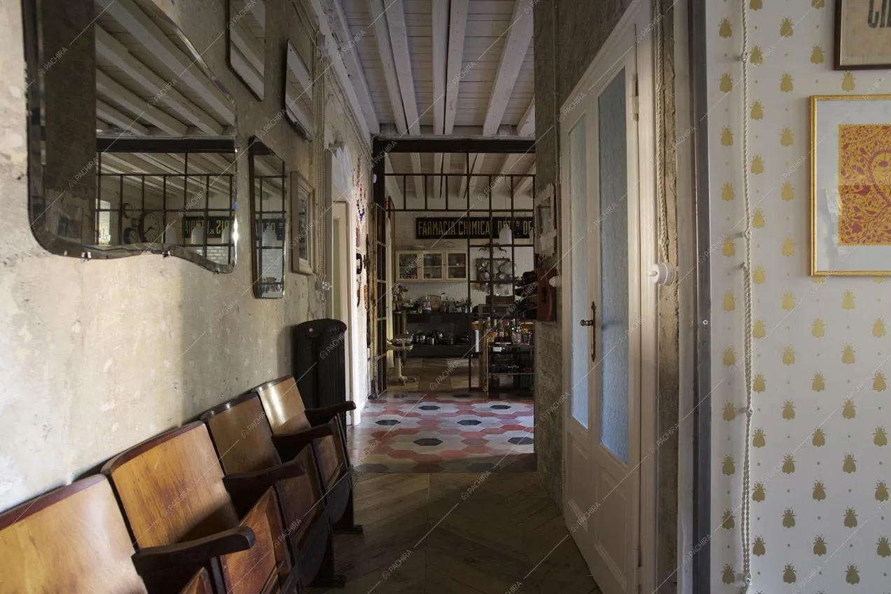 Sedie da cinema in legno nel corridoio, scorcio su soggiorno e cucina