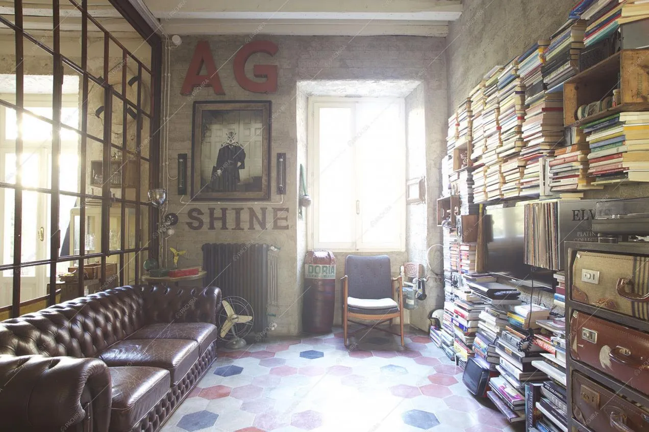 Soggiorno con divano in pelle, pavimento in cementine esagonali, libreria