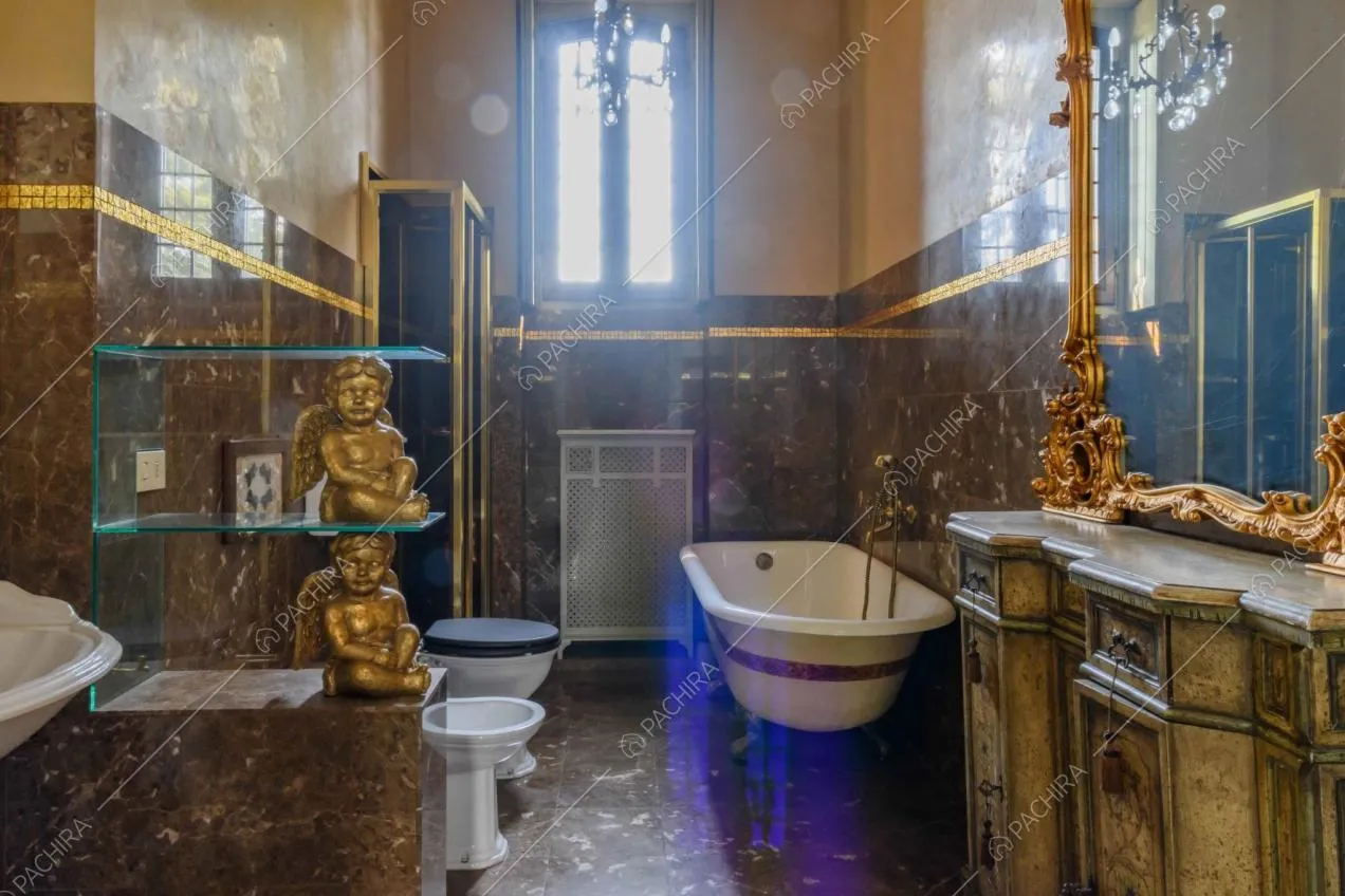 Bagno dalle pareti in marmo marrone in stile barocco con vasca