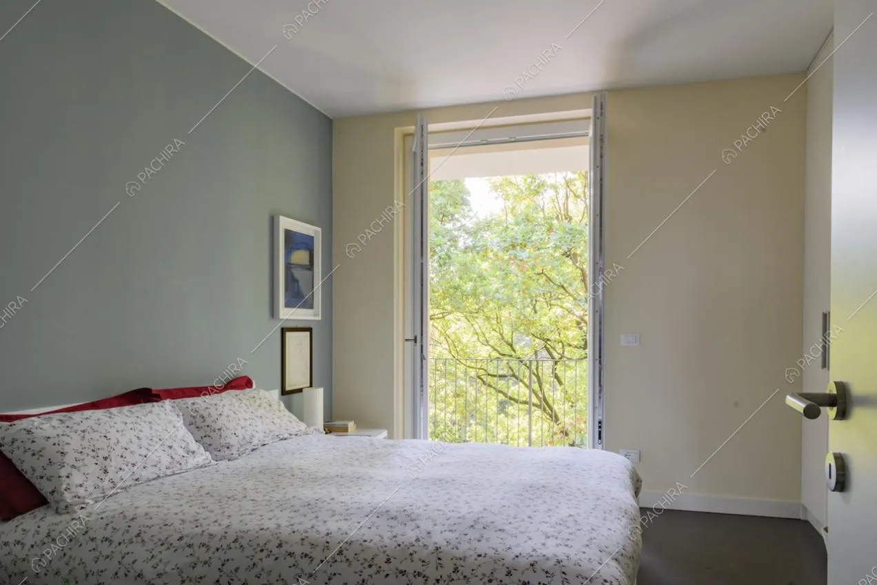 Camera da letto dai toni neutri con vista sul giardino