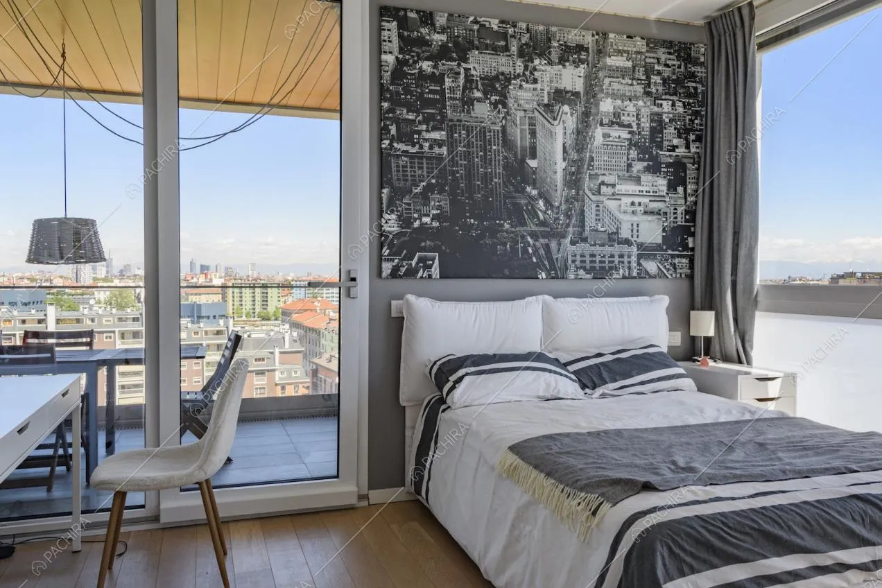 Camera da letto con grandi finestre e parquet