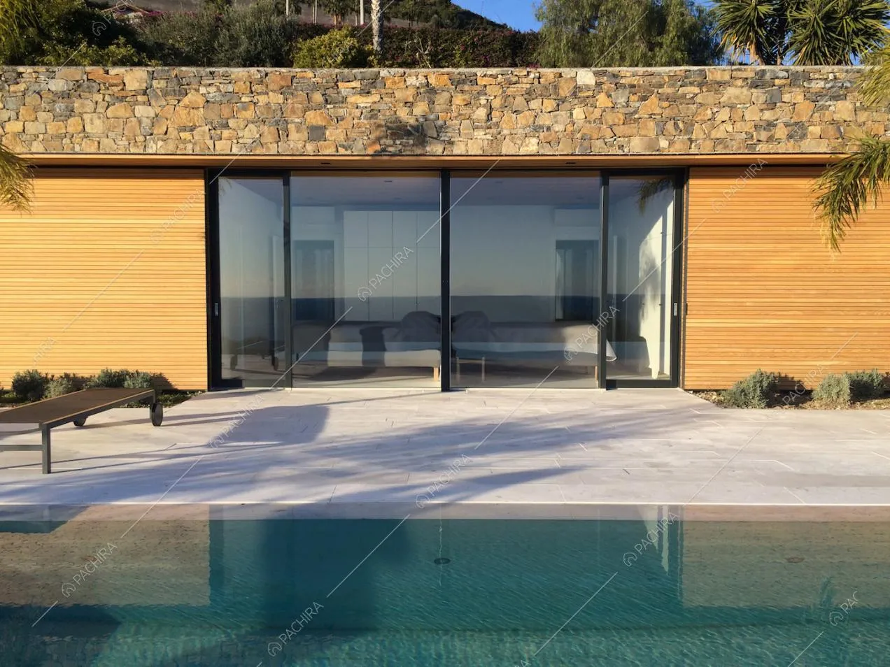 Dalla piscina vista sulle camere da letto della villa, attraverso le porte-finestre scorrevoli