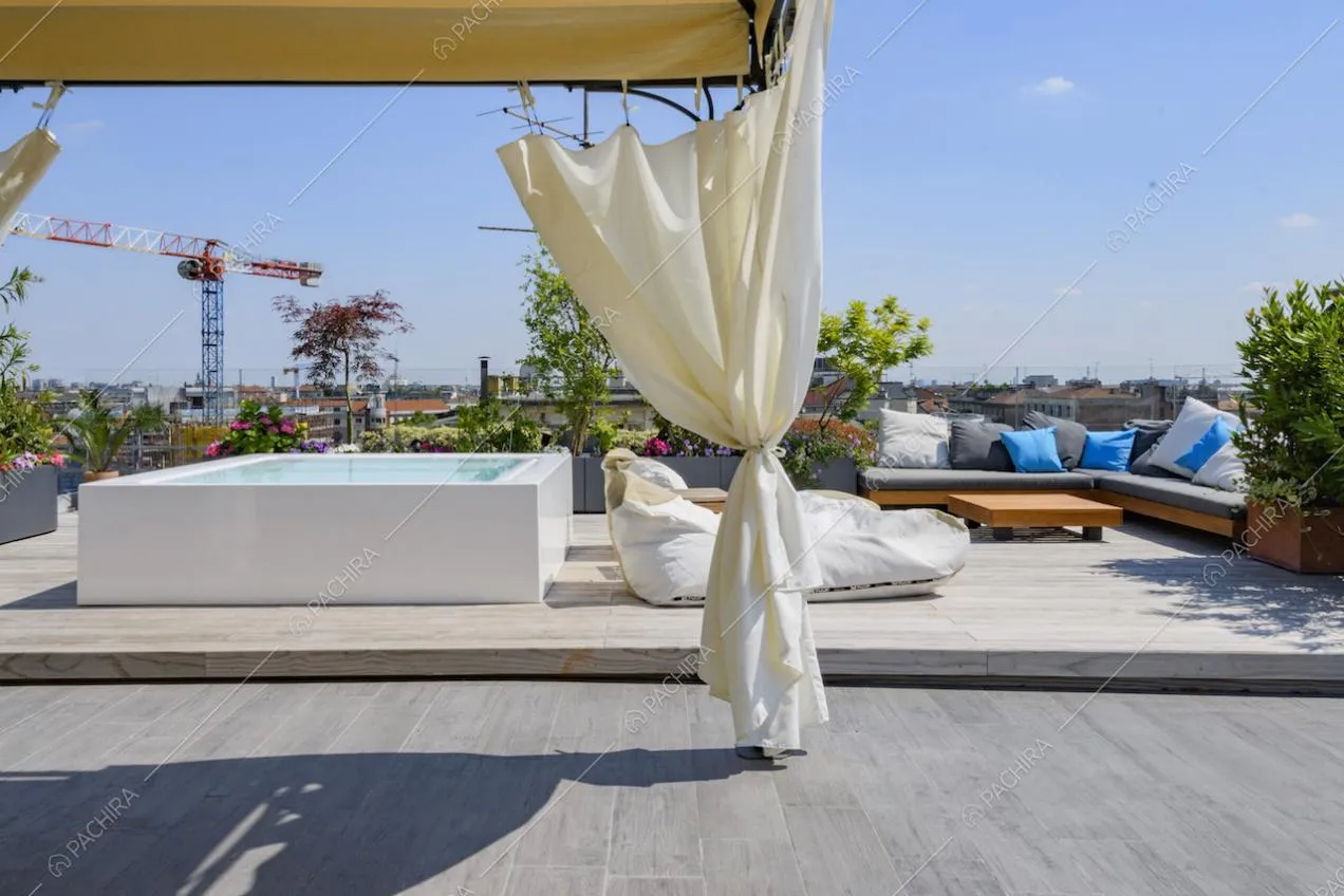Terrazza con gazebo, divanetti con cuscini e piscina