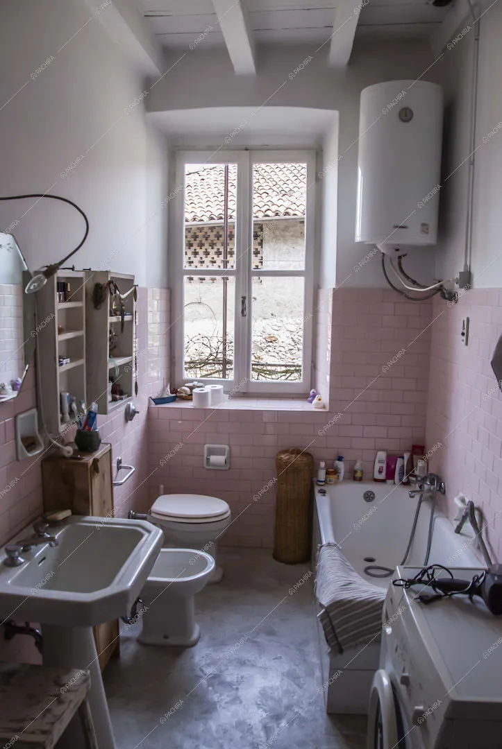 Bagno con pareti in piastrelle a mattoncini rosa