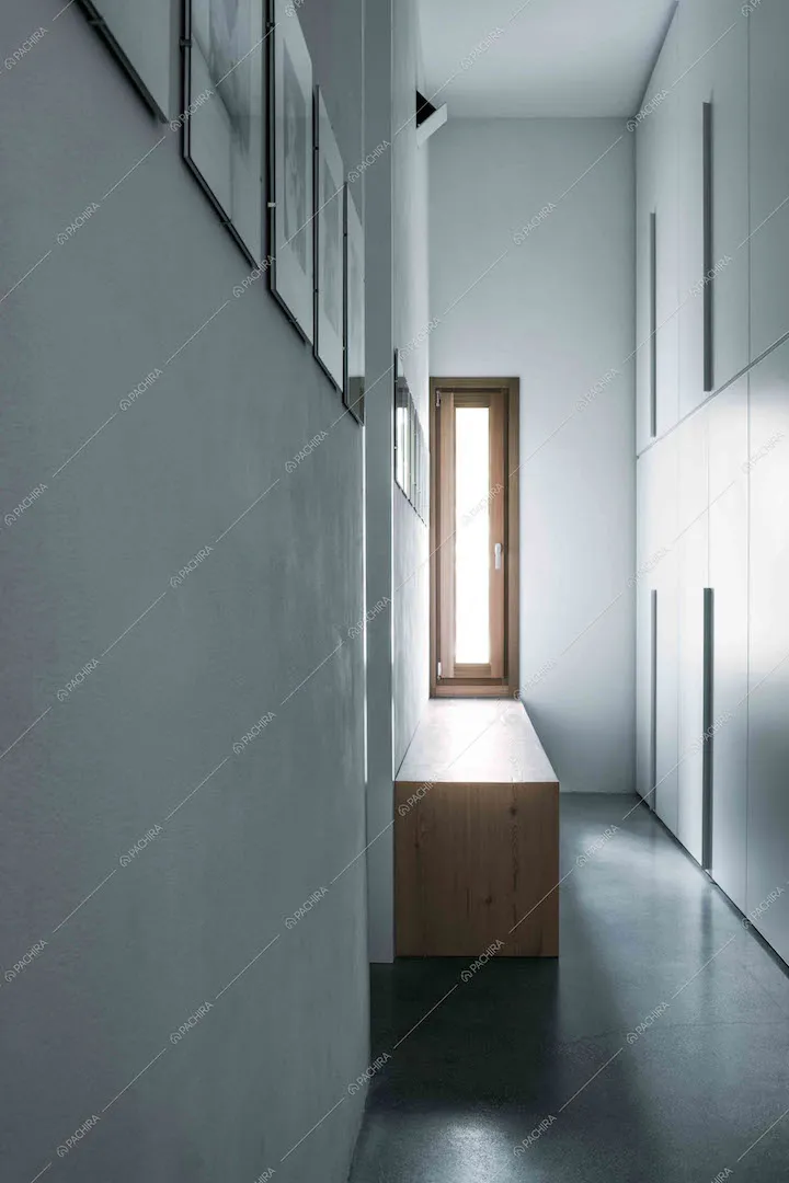 Corridoio con pavimento in cemento lisciato, mobile in legno