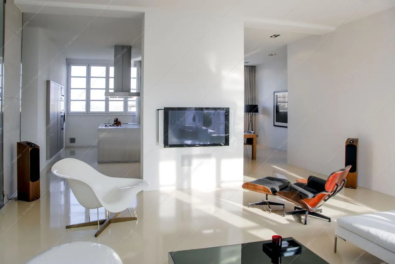 Zona living con poltrone di design e vista sulla cucina