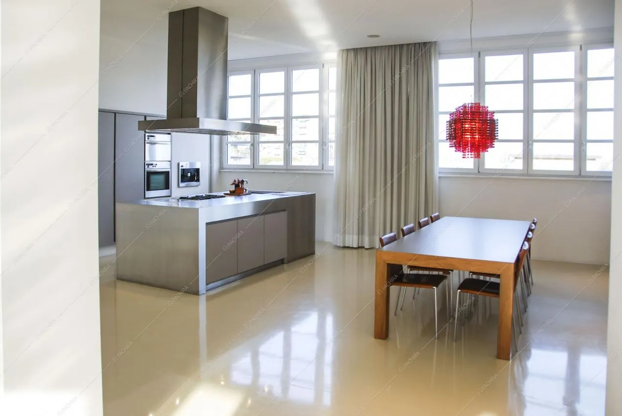 Zona cucina minimal con tavolo da pranzo e isola in acciaio