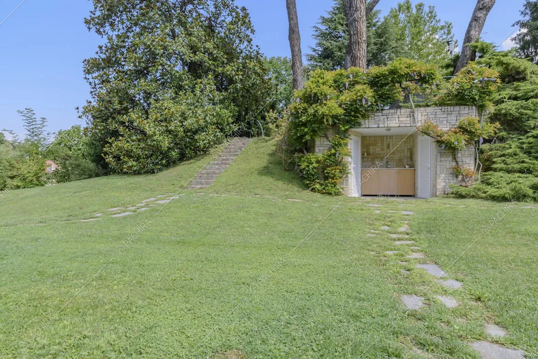 Casetta in pietra coperta di piante nel parco della Location Sulla