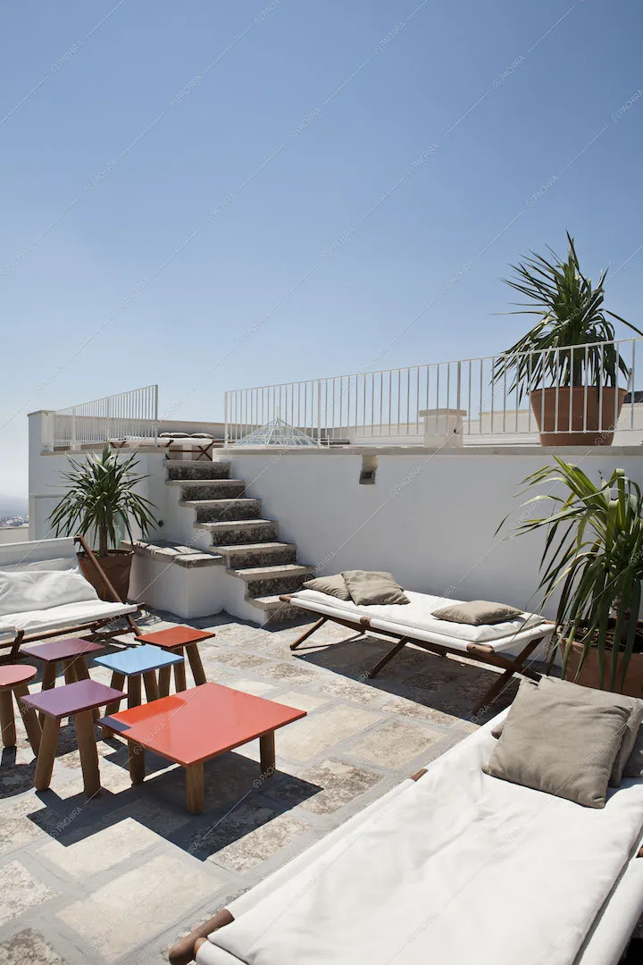 Terrazza con tavolini colorati, sdraio e divani
