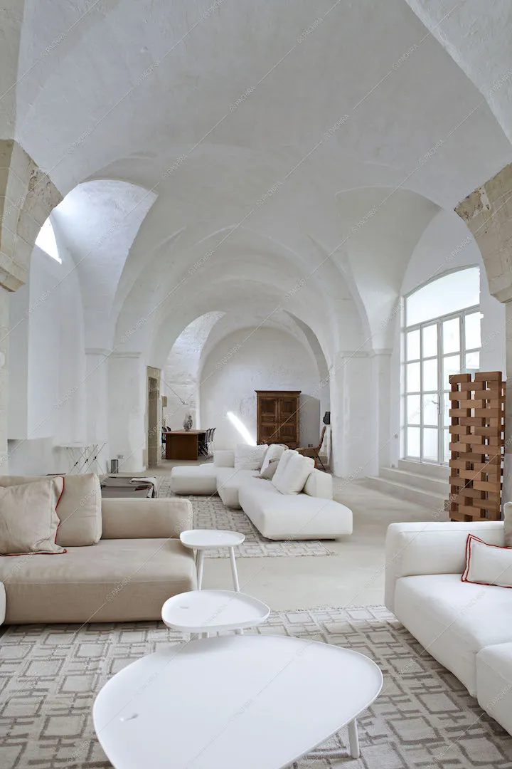 Zona living con più divani, soffitto bianco a volte