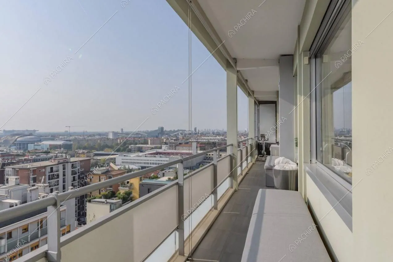 Panca grigia sulla terrazza con vetrate e vista sullo skyline