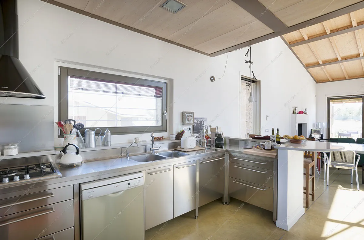 Cucina a penisola in acciaio con fornelli a gas