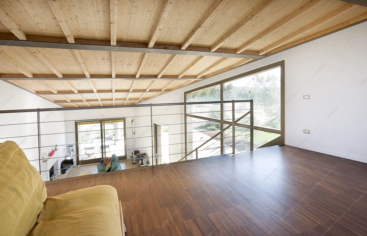 Vista della zona living dal soppalco con pavimento in parquet