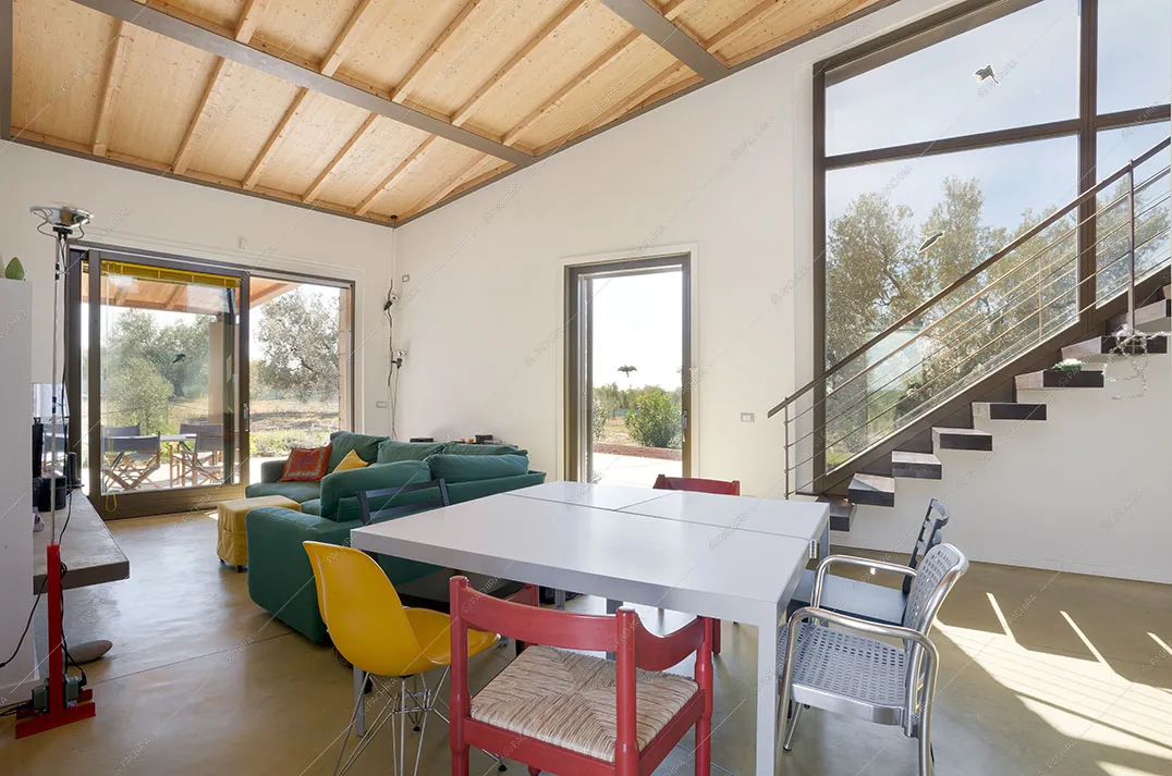 Tavolo da pranzo quadrato, travi a vista, vetrate