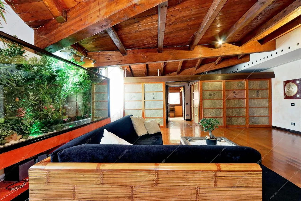 Zona living con giardino d'inverno  e pareti scorrevoli in stile giapponese