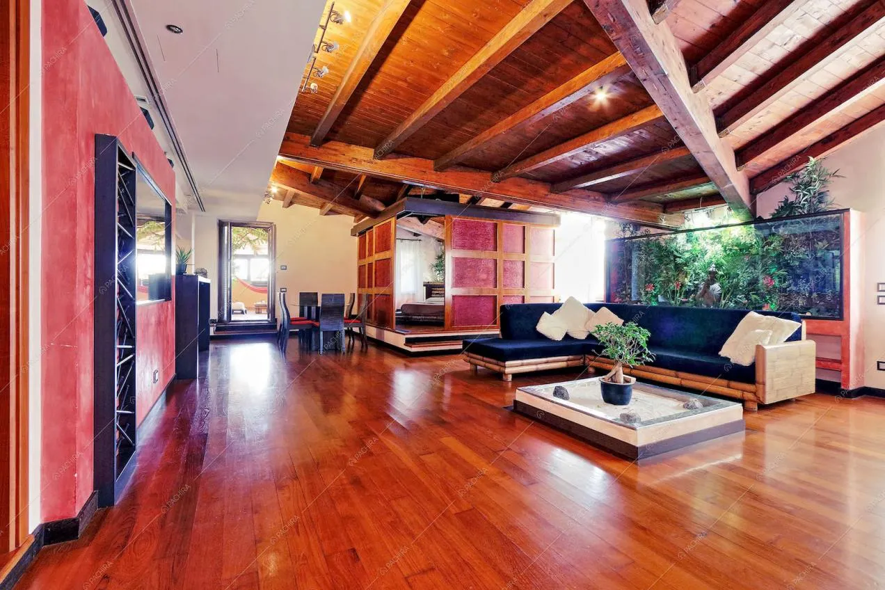 Zona living con parquet e soffitto con travi a vista